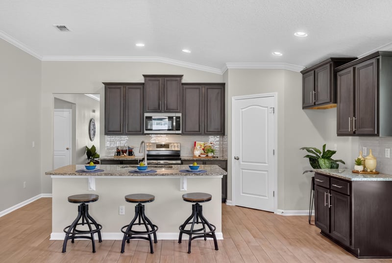 Kitchen with island, bar stools and dark cabinets at 10066 Andean Fox Dr, Jacksonville, FL 32222