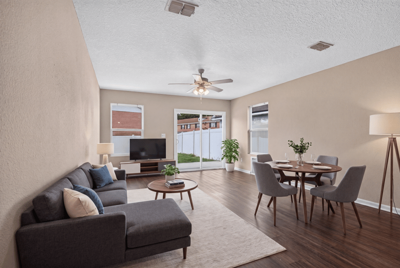 Living and dining area virtually staged with sofa and table at 7253 Townsend Village Ct, Jacksonville, FL