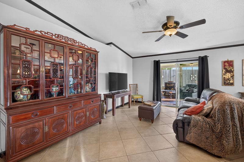 Living room with wood cabinet and TV stand at 6931 Cane Grass Ln E, Jacksonville, FL 32244