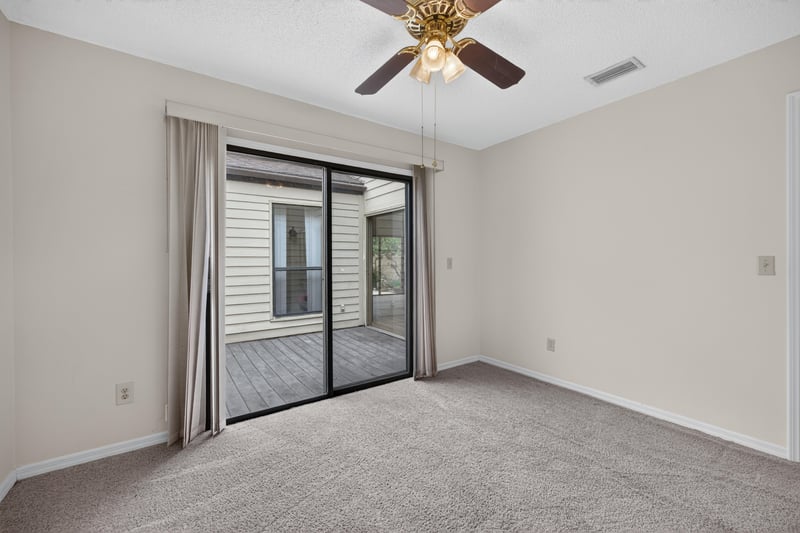 Carpeted room with sliding door to deck at 3407 Fairbanks Grant Rd N, Jacksonville, FL 32223