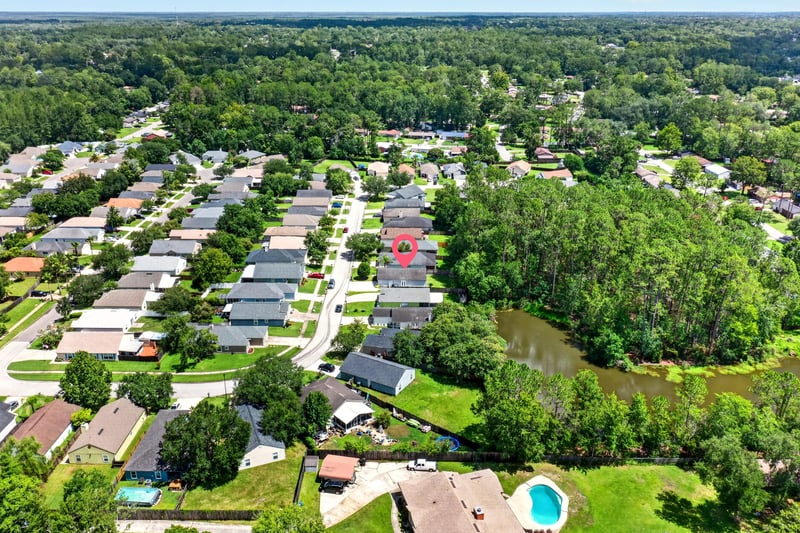 Drone aerial of rooftops and a pond in Middleburg, FL