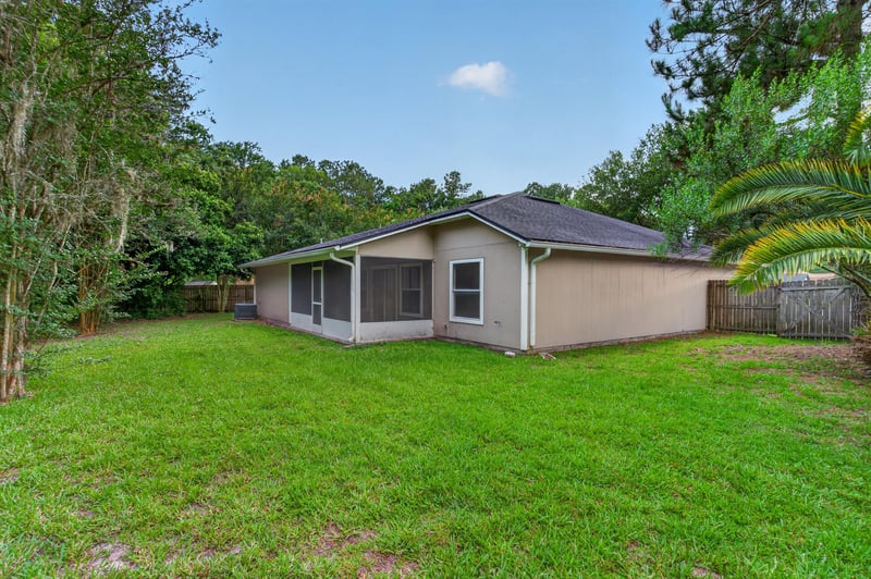 Rear exterior with lawn and screened porch at 1648 Glen Laurel Dr, Middleburg, FL 32068