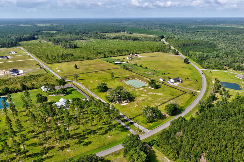 Wide aerial view of the property among neighboring ponds and homes at 7500 Lucky Seven Rnch Rd, Macclenny, FL