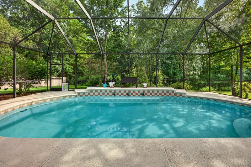 Screened pool surrounded by trees at 2125 Blue Heron Cove Dr, Orange Park, FL 32003