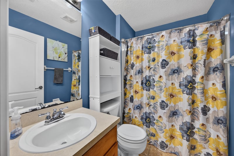 Bathroom with floral shower curtain and vanity at 3112 Silverado Cir, Green Cove Springs, FL 32043