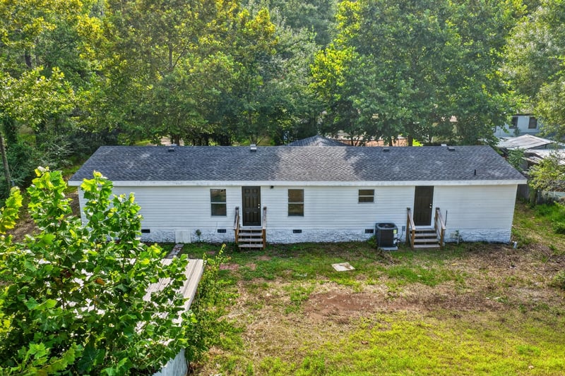 Rear exterior with metal roof and wood deck at 55520 Jewel-Thomas Rd, Callahan, FL 32011
