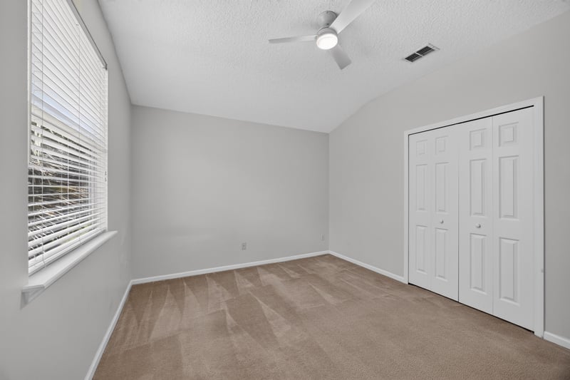 Bedroom with closet doors and carpet at 2480 Ridge Will Dr, Jacksonville, FL 32246