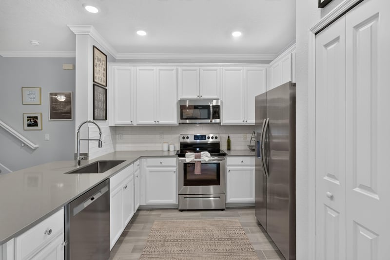Kitchen with white cabinets and stainless range at 1186 Beach Dune Dr, Jacksonville, FL 32233