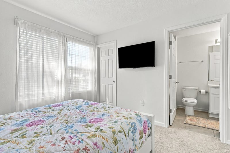 Bedroom with TV and door to ensuite bath at 8359 Zenith Cir, Jacksonville, FL 32256