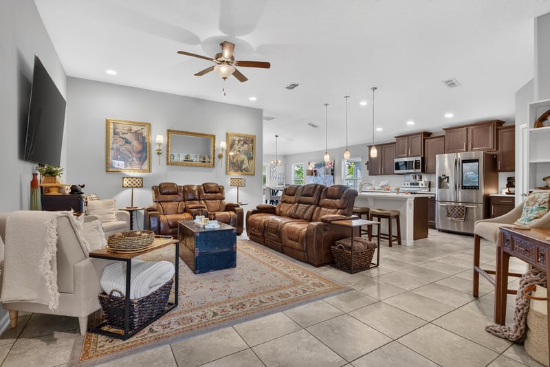 Living room open to kitchen with sectional and TV at 589 Seville Pkwy, St. Augustine, FL