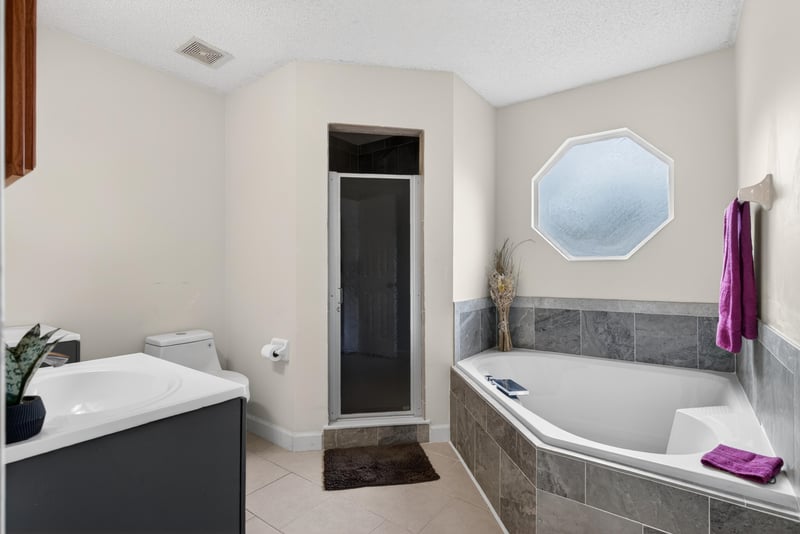 Bathroom with soaking tub and mirror at 2164 Orangewood St, Middleburg, FL 32068