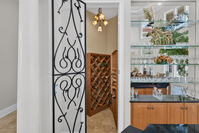 Wine room with wrought iron door and glass shelving at 344 Broward Rd, Jacksonville, FL