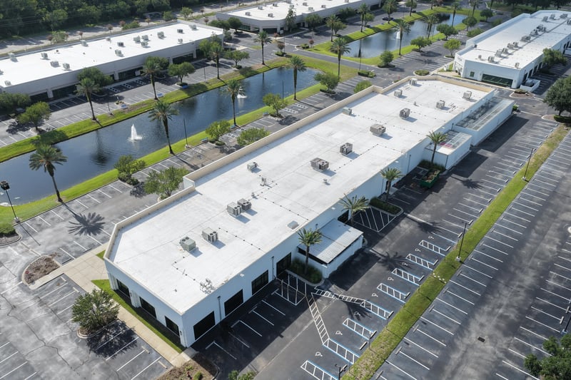 Aerial view of a building roof with pond and parking lot at 10550 Deerwood Park Blvd, Jacksonville, FL 32256
