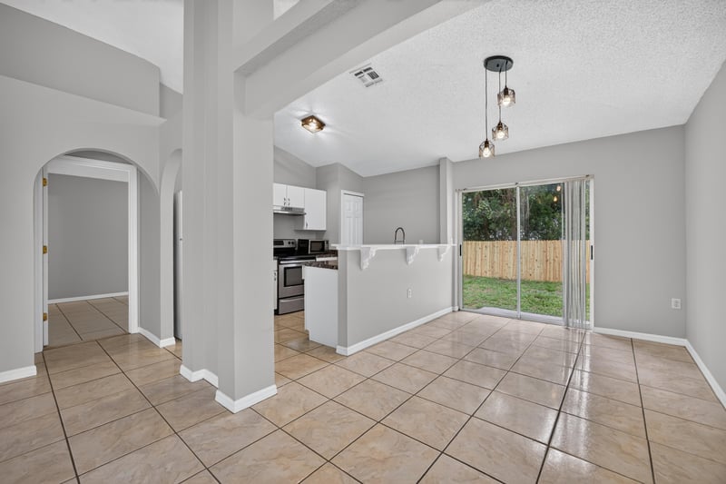 Kitchen and dining area with tile floor and sliding glass door at 7329 Lawn Tennis Ln, Jacksonville, FL