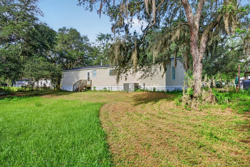 Side yard with oak trees and open lawn at 3215 Robin Ln, Middleburg, FL