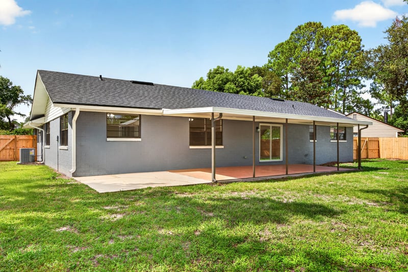Rear exterior with covered patio and palm tree at 4117 Wilcrest Ct, Jacksonville, FL 32277