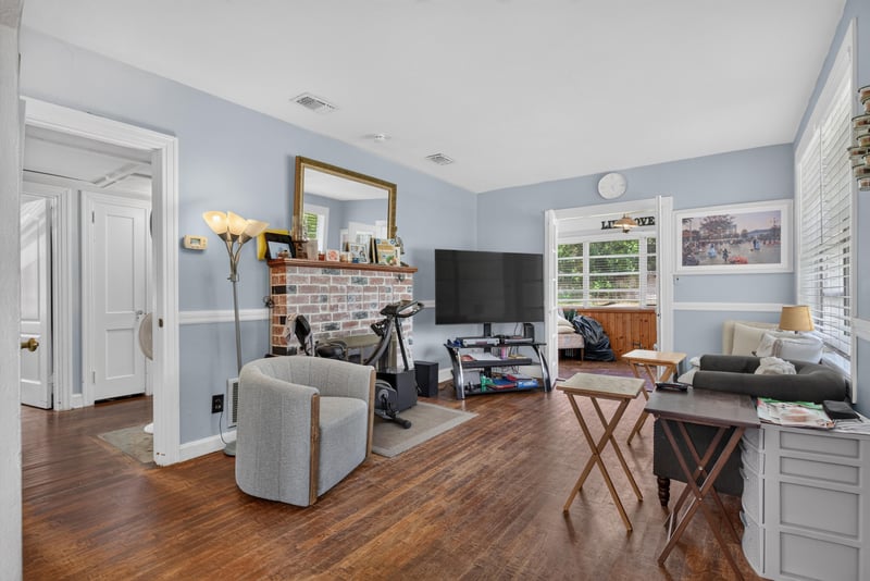 Living room with brick fireplace and hardwood floor at 5745 110th St, Jacksonville, FL 32244