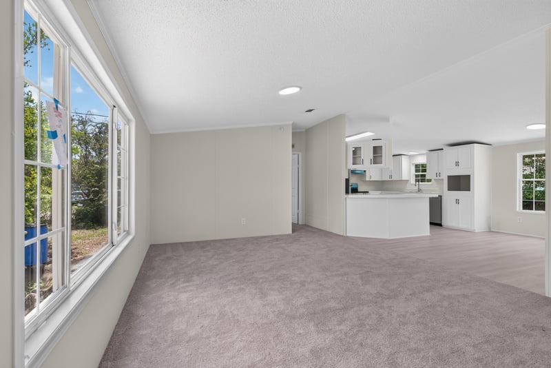 Living area with large window and kitchen beyond at 7603 Coach Park Dr, Jacksonville, FL 32244