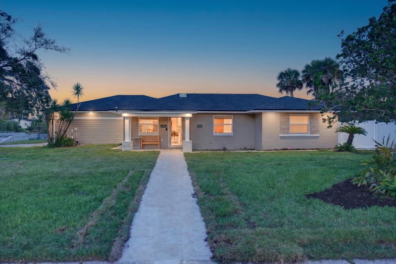 Front exterior at day-to-dusk with porch lights on at 1525 8th St N, Jacksonville Beach, FL