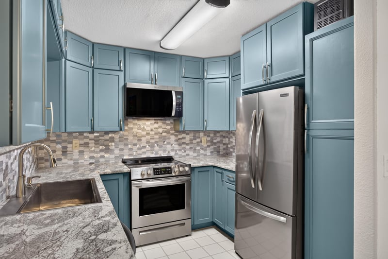 Kitchen sink area with window and blue cabinets at 10150 Belle Rive Blvd, Jacksonville, FL