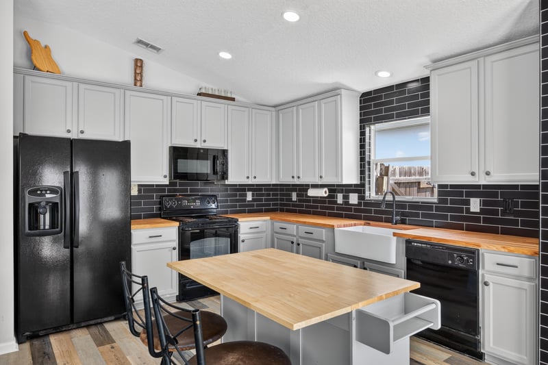 Kitchen with black appliances and island seating at 2065 Creekmont Dr