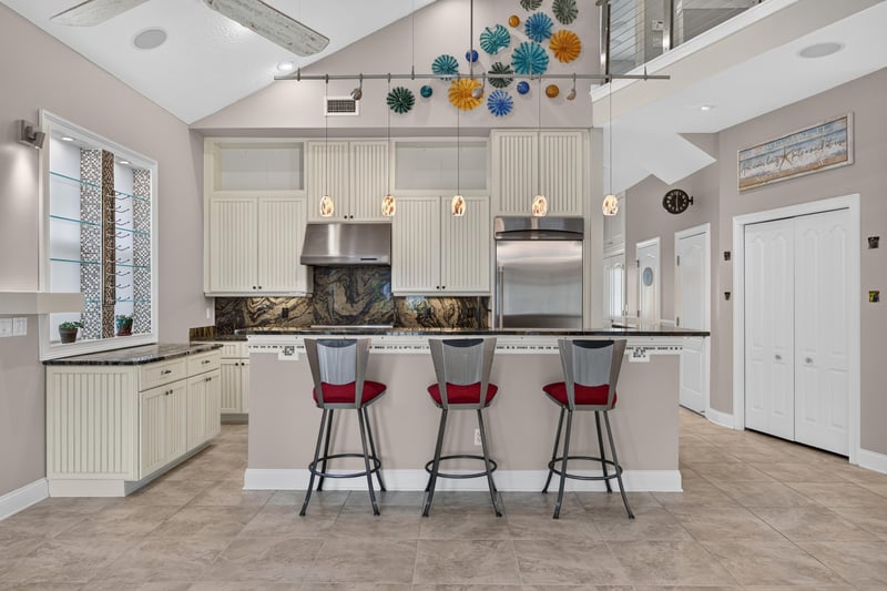 Kitchen with white cabinets and island seating at 117 Island Cottage Way, St. Augustine, FL 32080
