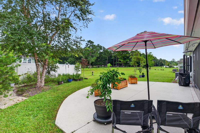Backyard patio seating under umbrella at 4319 Green River Pl, Middleburg, FL 32068