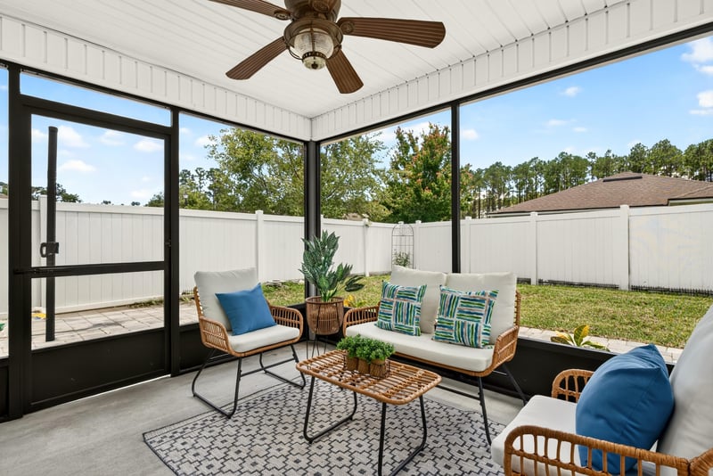 Screened porch with wicker seating and area rug at 10066 Andean Fox Dr, Jacksonville, FL 32222