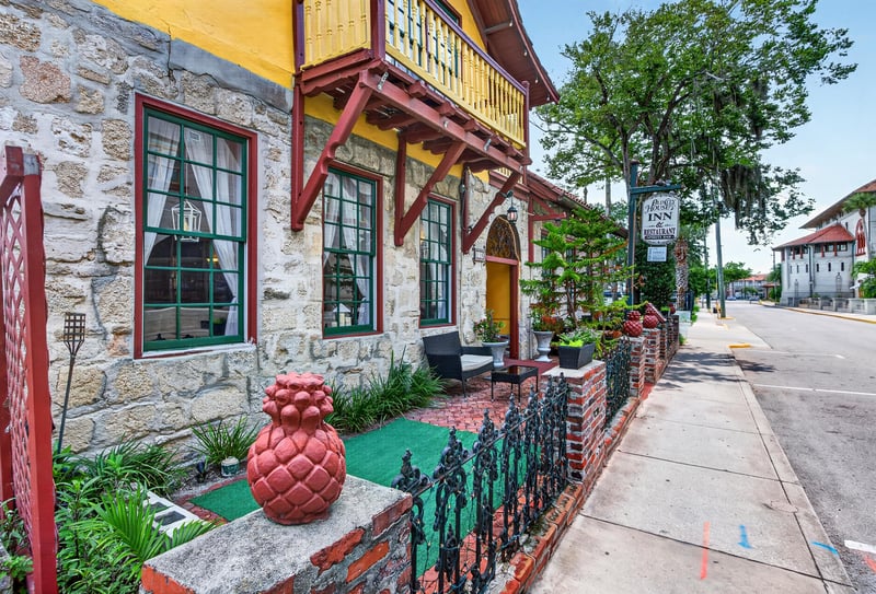 Front porch with wood trim windows and a hanging sign at 115 Cordova St, St. Augustine, FL
