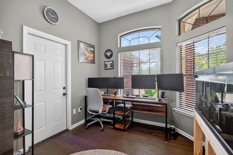 Home office with built-in desk and monitors at 2125 Blue Heron Cove Dr, Orange Park, FL 32003