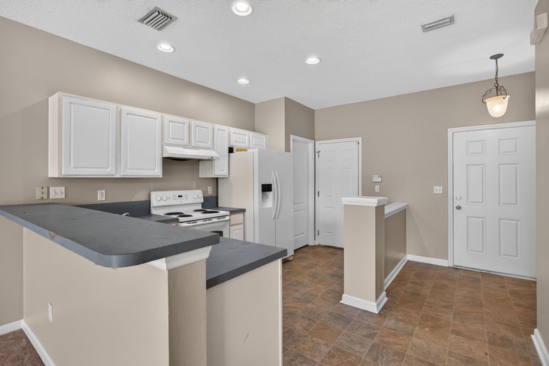 Kitchen pass-through with tile flooring and white appliances at 1572 Biscayne Bay Dr, Jacksonville, FL 32218