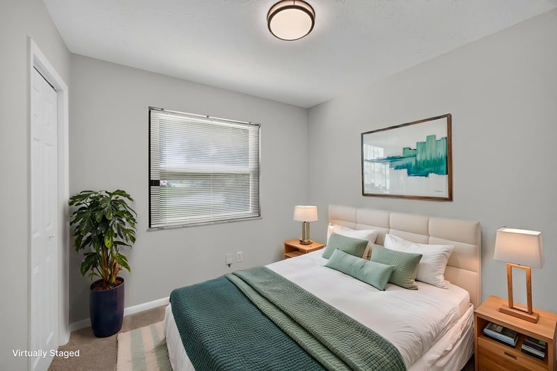 Virtually staged bedroom with green bedding and nightstands at 7453 Jade Dr N, Jacksonville, FL 32210