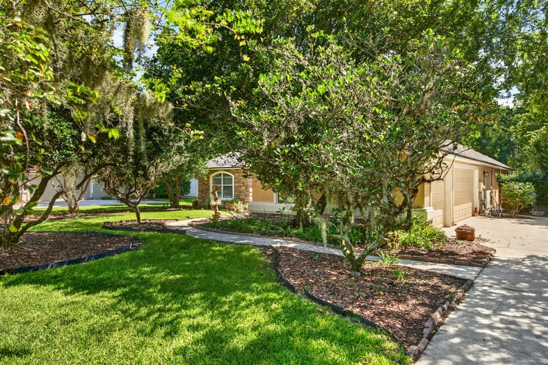 Front walkway and lawn shaded by oaks at 11675 Magnolia Estates Rd, Jacksonville, FL 32223
