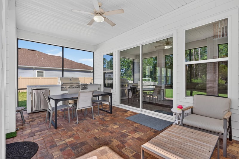 Screened porch with dining area and ceiling fan at 22 Azura Point