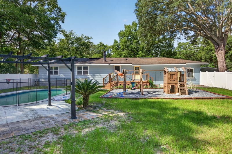 Backyard pool with pergola and playground at 892 Branscomb Rd, Green Cove Springs, FL