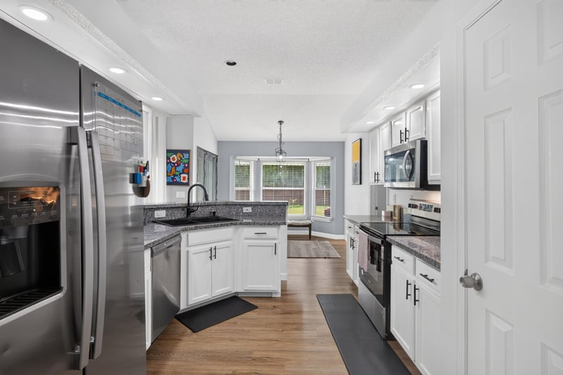 Kitchen with stainless refrigerator and white cabinets at 8921 Needlepoint Pl, Jacksonville, FL 32244