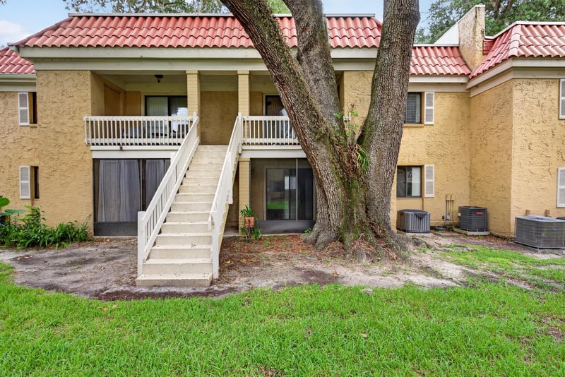 Condo building exterior with stairs and oak tree at 5811 Atlantic Blvd unit 47, Jacksonville, FL 32207