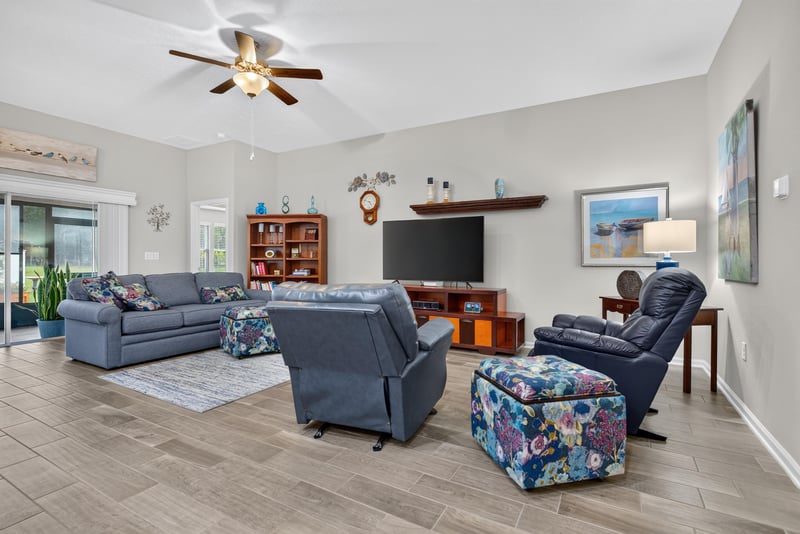 Living room with ceiling fan and sofas at 4319 Green River Pl, Middleburg, FL 32068