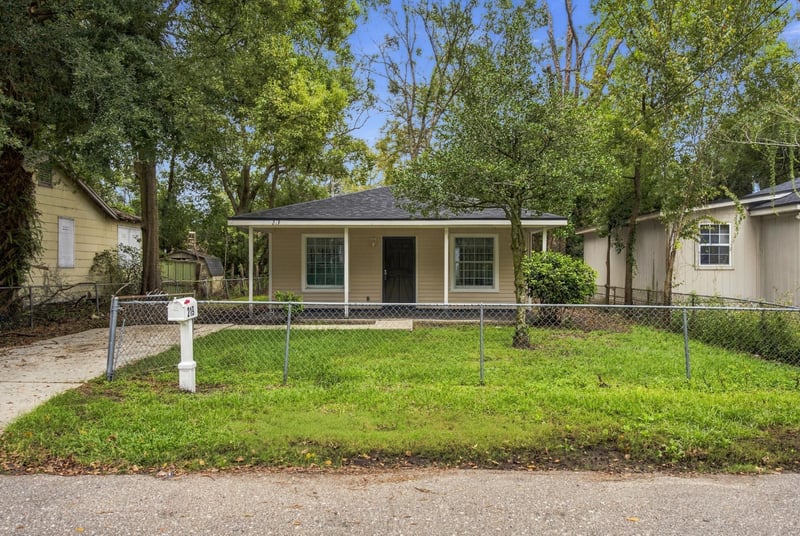 Front view of single story home with tan siding and fenced yard at 219 Shortreed St, Jacksonville, FL 32254