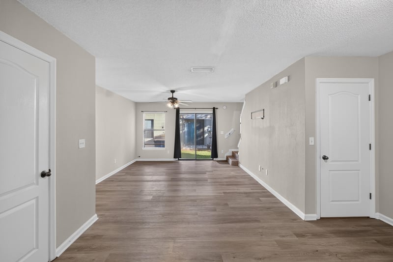 Open living area with ceiling fan and sliding door to backyard at 7723 Playschool Ln, Jacksonville, FL