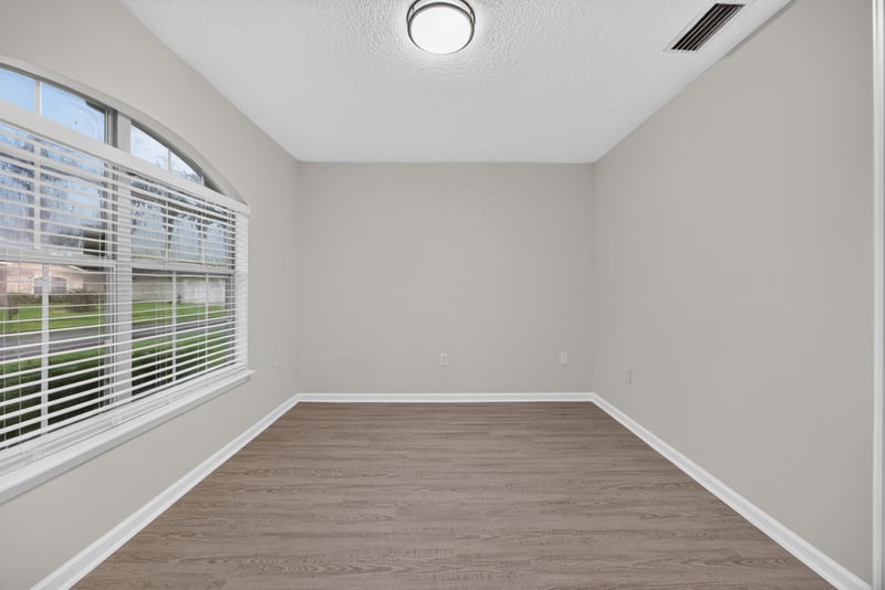 Empty room with wood-look flooring and windows at 706 Bonaparte Dr, Jacksonville, FL 32218