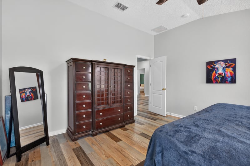 Primary bedroom with standing mirror and dresser at 2065 Creekmont Dr