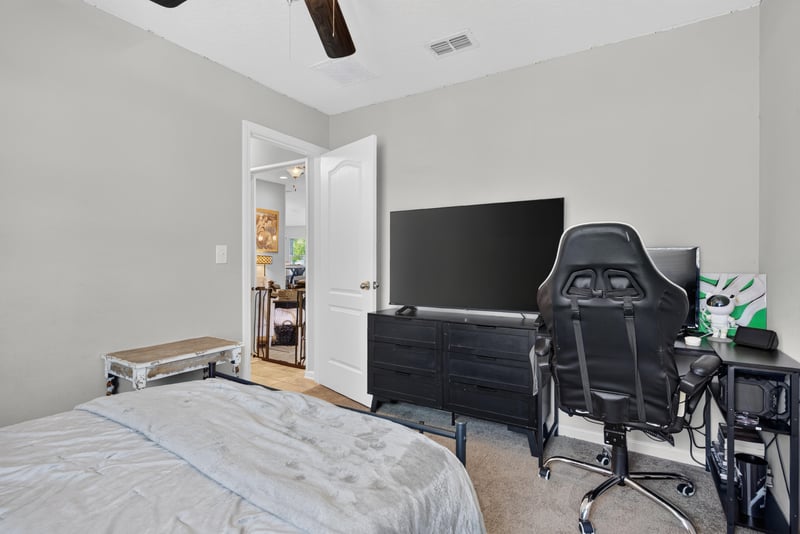 Bedroom with gaming chair and mounted TV at 589 Seville Pkwy, St. Augustine, FL