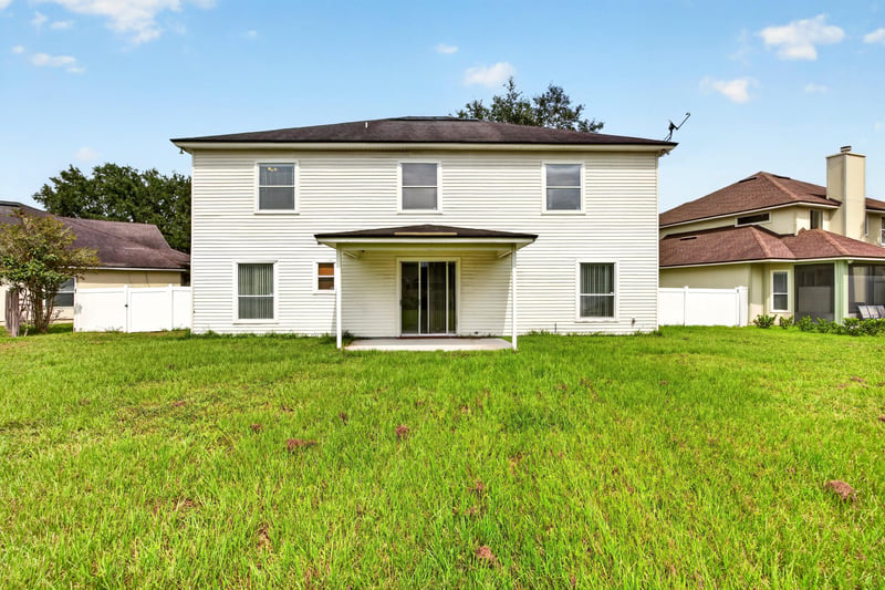 Back exterior with large lawn at 2875 Pebblewood Ln, Orange Park, FL 32065