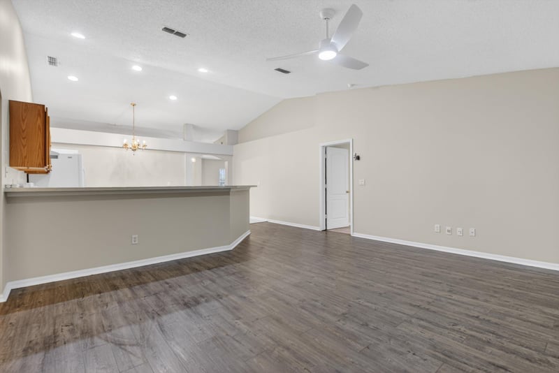 Open living area with wood flooring and pass-through to kitchen at 1648 Glen Laurel Dr, Middleburg, FL 32068