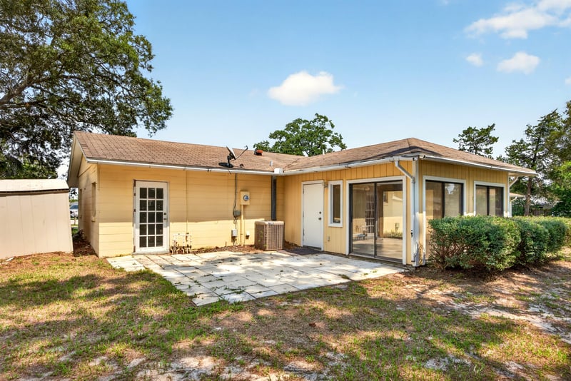 Back exterior with concrete patio and AC unit at 328 Palos Ct, St. Augustine, FL