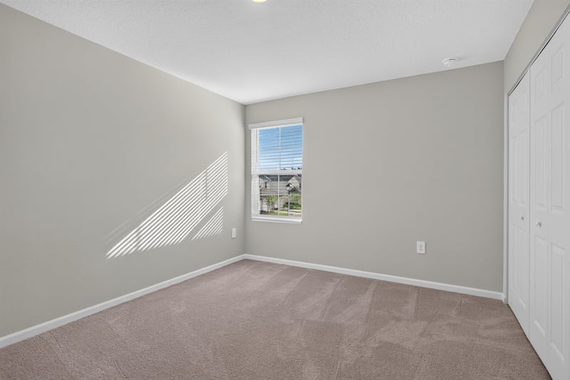 Third bedroom corner with window and carpet at 4024 Bay Hawk Ct, Jacksonville, FL