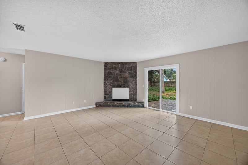 Living room with stone accent wall and tile floor at 1040 Willow Cove Ct E, Jacksonville, FL 32233
