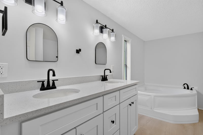 Primary bathroom with dual vanity and arched mirrors at 55520 Jewel-Thomas Rd, Callahan, FL 32011