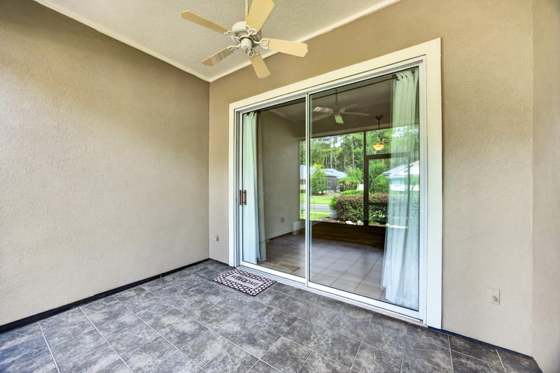 Carpeted room with sliding glass door to patio at 2131 E Stone Creek Dr, Fleming Island, FL